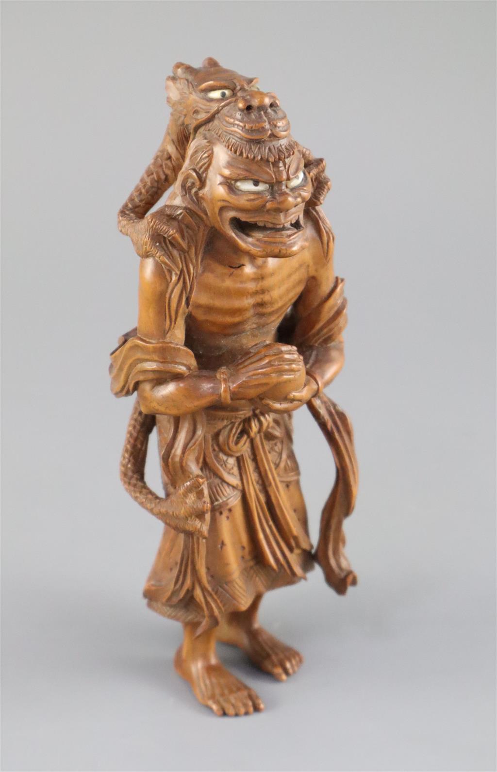 A fine Japanese boxwood okimono of the Sennin Handaka Sonja with a dragon clambering on his back, 19th century, signed Masakazu, 16.5cm